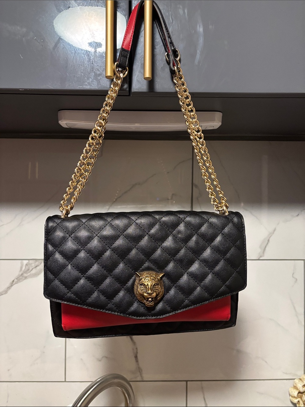 Black Quilted Shoulder Bag with Red Accent and Gold Chain